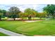 Scenic view of a golf course featuring lush greens, mature trees, and meticulously maintained fairways under a cloudy sky at 54 Camino Real Blvd # 504, Howey In The Hills, FL 34737