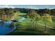 Scenic golf course view featuring lush green fairways, a winding creek, a stone bridge, and mature trees in a peaceful setting at 54 Camino Real Blvd # 504, Howey In The Hills, FL 34737