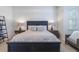 Stylish main bedroom has a large bed, big windows, and two lamps at 54 Camino Real Blvd # 504, Howey In The Hills, FL 34737