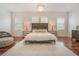 Beautiful main bedroom with hardwood floors, dresser, two side tables, and an ottoman at 54 Camino Real Blvd # 504, Howey In The Hills, FL 34737