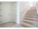 Carpeted stairs with white railing, next to two white doors on the first level of the home at 54 Camino Real Blvd # 504, Howey In The Hills, FL 34737