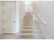 Bright staircase featuring neutral carpet and white railings, leading to the upper level at 54 Camino Real Blvd # 504, Howey In The Hills, FL 34737