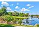 Expansive view of the community pond, with a fountain, bridge, surrounding lush greenery and a clear blue sky with fluffy clouds at 54 Camino Real Blvd # 504, Howey In The Hills, FL 34737