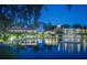 Night time water view featuring community buildings reflected in the water, accented by ambient lighting and serene surroundings at 54 Camino Real Blvd # 504, Howey In The Hills, FL 34737