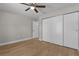 A bedroom with wood floors, neutral walls, a ceiling fan, and a sliding-door closet at 565 Malauka Radl, Ocklawaha, FL 32179