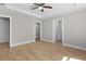 A bedroom with modern flooring, neutral walls, ceiling fan, and an en-suite bathroom entrance at 565 Malauka Radl, Ocklawaha, FL 32179