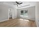 A spacious bedroom featuring wood floors, a ceiling fan, and natural light from a large window at 565 Malauka Radl, Ocklawaha, FL 32179