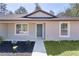 Close-up of an inviting front door and fresh landscaping, creating an attractive and welcoming entrance at 565 Malauka Radl, Ocklawaha, FL 32179