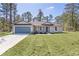 Charming home with blue garage door, landscaped front yard, and inviting curb appeal at 565 Malauka Radl, Ocklawaha, FL 32179