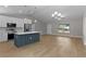 Spacious open-concept kitchen with an island, stainless appliances, and adjacent living area for modern living at 565 Malauka Radl, Ocklawaha, FL 32179