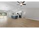 Open-concept kitchen and living area with island, wood floors, and vaulted ceiling at 565 Malauka Radl, Ocklawaha, FL 32179