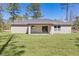 Spacious rear view featuring covered patio and a vast, well-manicured lawn ideal for outdoor living at 565 Malauka Radl, Ocklawaha, FL 32179