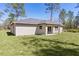 Expansive home rear showcasing lush lawn, inviting patio, and seamless indoor-outdoor flow at 565 Malauka Radl, Ocklawaha, FL 32179