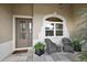Charming front entrance with a decorative glass door, arched window, and cozy seating area at 712 Krietemeyer Path, The Villages, FL 32163