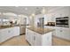 Well-lit kitchen with an island, stainless steel appliances, granite countertops, and ample white cabinetry at 712 Krietemeyer Path, The Villages, FL 32163