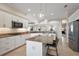 Bright kitchen featuring white cabinetry, granite countertops, stainless steel appliances, and an island with bar seating at 712 Krietemeyer Path, The Villages, FL 32163