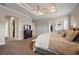 Bright main bedroom featuring a tray ceiling, ceiling fan, and access to the lanai at 712 Krietemeyer Path, The Villages, FL 32163