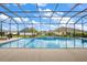 Beautiful screened in pool and patio with sunny skies above and lush landscaping surrounding the area at 712 Krietemeyer Path, The Villages, FL 32163