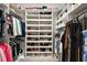 Organized walk-in closet with built-in shelving and rods for clothes, shoes, and accessories at 712 Krietemeyer Path, The Villages, FL 32163