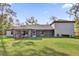 The backyard features a spacious lawn and covered patio of this beautiful home at 73 Bay Dr, Ocklawaha, FL 32179