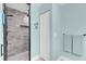 Bathroom showcasing a tiled shower with glass doors, complemented by a linen closet and fresh blue walls at 73 Bay Dr, Ocklawaha, FL 32179