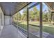 View of a screened-in porch with ample lighting and an entrance to the large green backyard at 73 Bay Dr, Ocklawaha, FL 32179