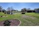 Landscaped backyard view highlighting a serene lake, mature trees, and partial pool view at 7812 Se 167Th Mistwood Ln, The Villages, FL 32162