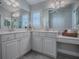 Bathroom with a white dual sink vanity, a large mirror, and white cabinets at 7812 Se 167Th Mistwood Ln, The Villages, FL 32162