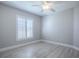 This bedroom features wood-look floors, white trim, gray walls, white shutters, and a ceiling fan at 7812 Se 167Th Mistwood Ln, The Villages, FL 32162