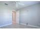 Bedroom with wood-look floors, gray walls, white trim, ceiling fan, and an open door at 7812 Se 167Th Mistwood Ln, The Villages, FL 32162