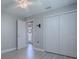 Bedroom with wood-look floors, gray walls, white trim, ceiling fan, and double closet at 7812 Se 167Th Mistwood Ln, The Villages, FL 32162