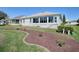 Rear exterior showcasing the sunroom, white trim, and surrounding landscaped yard at 7812 Se 167Th Mistwood Ln, The Villages, FL 32162