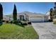 Charming single-story home boasts a three-car garage, a well-manicured lawn, and lush landscaping at 7812 Se 167Th Mistwood Ln, The Villages, FL 32162