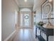 Inviting foyer showcases a decorative front door, an elegant console table, and wood-look flooring at 7812 Se 167Th Mistwood Ln, The Villages, FL 32162