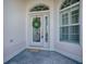 Close-up of the front door featuring decorative glass, sidelights, and a 'Welcome' mat at 7812 Se 167Th Mistwood Ln, The Villages, FL 32162