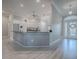 Bright, open kitchen with a breakfast bar, white cabinetry, and a view to the front door at 7812 Se 167Th Mistwood Ln, The Villages, FL 32162