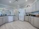 Open kitchen with stainless steel appliances, granite countertops, and light wood-look flooring at 7812 Se 167Th Mistwood Ln, The Villages, FL 32162