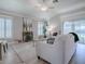 This living room features an open floor plan, white furniture, wood-look floors, and two shuttered windows at 7812 Se 167Th Mistwood Ln, The Villages, FL 32162