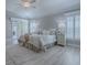 Sunlit main bedroom featuring plantation shutters, sliding door access, and neutral palette at 7812 Se 167Th Mistwood Ln, The Villages, FL 32162