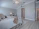 Bright main bedroom featuring a tray ceiling, neutral decor, and wood flooring at 7812 Se 167Th Mistwood Ln, The Villages, FL 32162