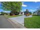 Charming single-story home featuring a screened-in porch and well-manicured landscaping with mature trees and greenery at 915 Oleander St, Lady Lake, FL 32159