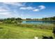 Scenic view of the lush green backyard and serene lake at 9729 Lost Creek Dr, Winter Garden, FL 34787