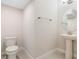 Powder room with pedestal sink, elongated toilet, and modern fixtures at 9729 Lost Creek Dr, Winter Garden, FL 34787