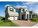 Charming two-story home featuring a three-car garage, brick driveway, and professionally landscaped front yard at 9729 Lost Creek Dr, Winter Garden, FL 34787