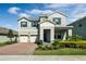Charming two-story home featuring a three-car garage, brick driveway, and professionally landscaped front yard at 9729 Lost Creek Dr, Winter Garden, FL 34787