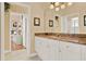 Bathroom vanity with granite countertop, white cabinets, and a large mirror at 995 Hidden Blf, Clermont, FL 34711