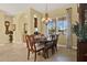 Elegant dining room with chandelier, wooden table, and large window with patterned drapes at 995 Hidden Blf, Clermont, FL 34711