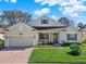 Charming single-Gathering home with a well-maintained lawn, brick driveway, and inviting front porch at 995 Hidden Blf, Clermont, FL 34711