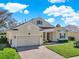 Beautiful one-story home featuring a brick driveway, two-car garage, and lush landscaping at 995 Hidden Blf, Clermont, FL 34711
