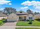 Charming one-story home with well-manicured lawn, brick driveway, and attached two-car garage at 995 Hidden Blf, Clermont, FL 34711